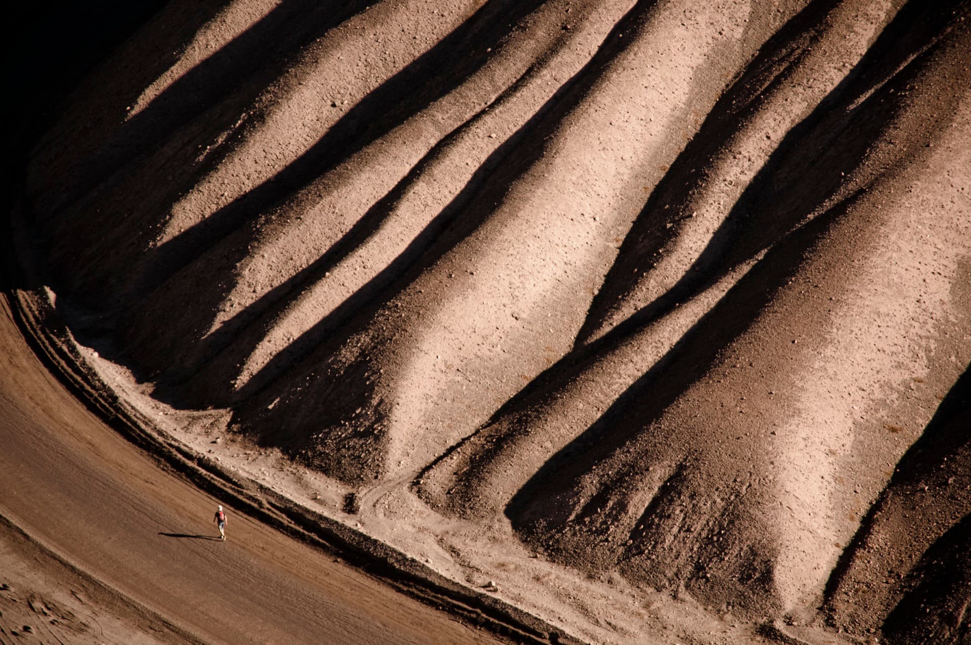 Ein Läufer durchquert die weite, zerklüftete Landschaft der Atacama