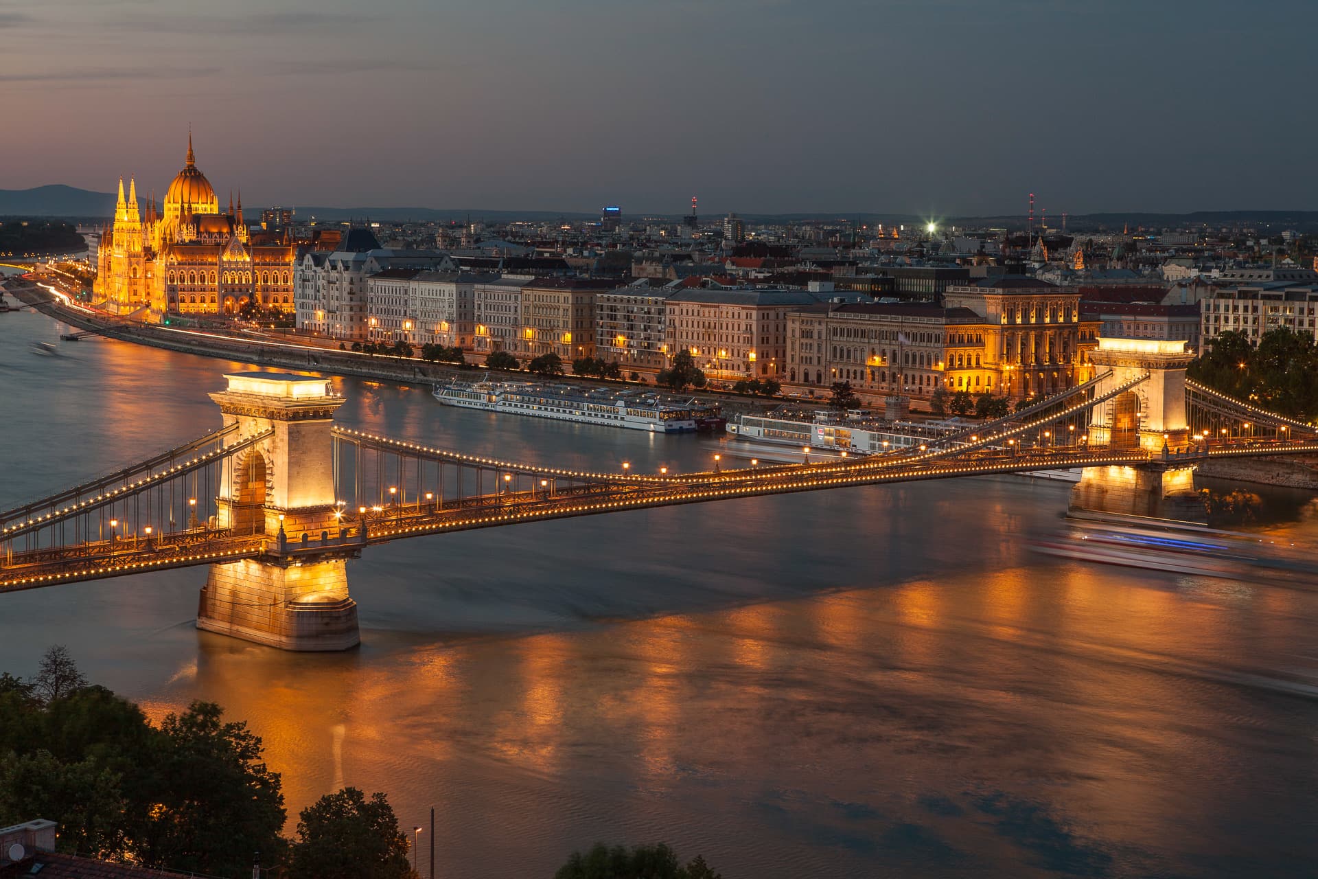 Die Donau und das beleuchtete Budapest in der Abenddämmerung